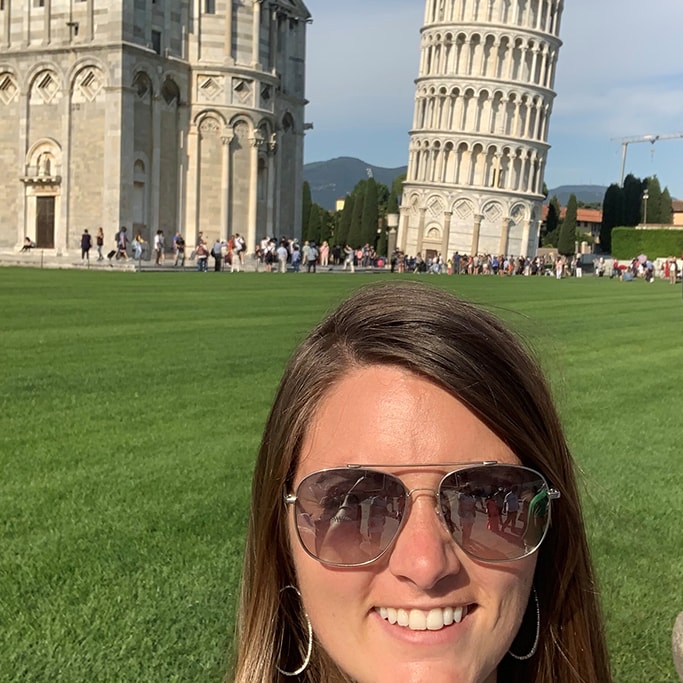 Courtney Naunheim standing in front of the Leaning Tower of Pisa